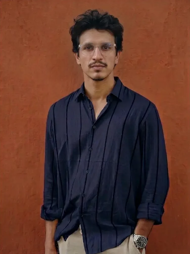Muhammad Jasim, local SEO specialist, standing against a terracotta wall